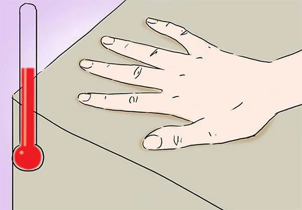 Een hand op traagschuim naast een thermometer: het schuim reageert op lichaamswarmte